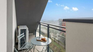 Un balcón con una mesa, una silla y un croissant.