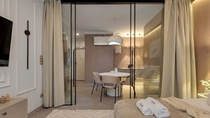 Ett hotellrum med en säng, ett skrivbord, en stol och en tv.