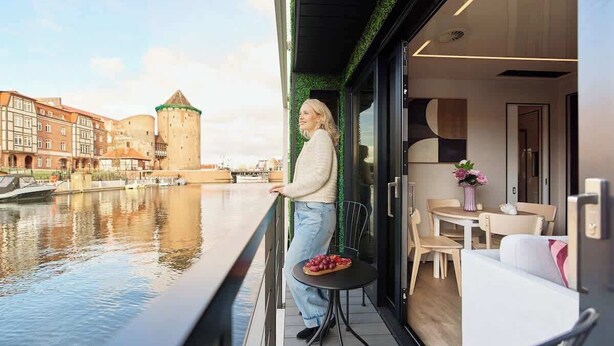 A balcony with a view of a historic building and a canal.