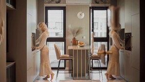 A modern kitchen with a central island, two chairs, and a dining table. - Sol Marina Harmony | Perfect View (Gdańsk)