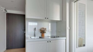 A modern kitchen with white cabinetry, a built-in sink, and a small countertop. - Tartaczna 17 | Perfect Stay (Gdańsk)