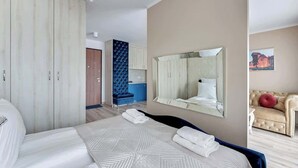 Een hotelkamer met een bed, een kledingkast, een spiegel, een bank en een blauwe stoel.