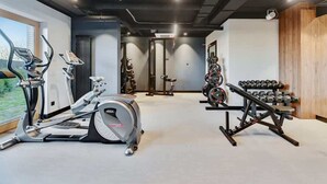 Een sportschool met trainingsapparatuur, een halterbank en een raam met uitzicht.