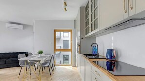 Een moderne keuken met witte kasten, een houten aanrechtblad en een ingebouwde oven.