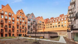 A residential building with multiple balconies, a central courtyard, and a modern architectural design. - Granaria B201 | Best Location (Gdańsk)
