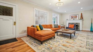 A living room with a sectional sofa, a coffee table, and a fireplace. - Spacious 4-bedroom Single Family home in Historic  Weequahic Newark NJ (Newark)