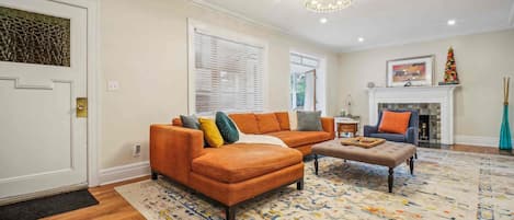 A living room with a sectional sofa, a coffee table, and a fireplace.