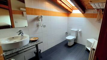 A bathroom with a sink, toilet, and shower.