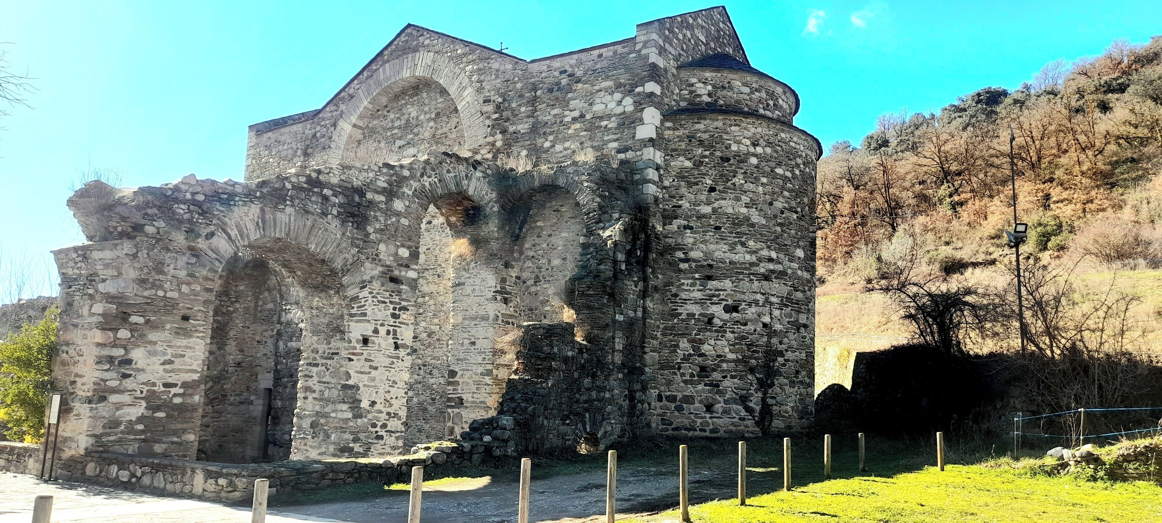 A historic stone building with arched windows and a tower.