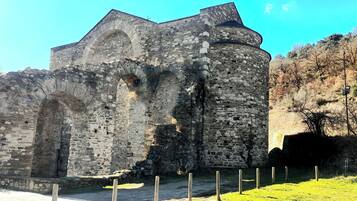 A historic stone building with arched windows and a tower.