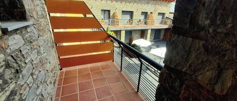 Un edificio de piedra con una escalera de baldosas que sube a un balcón.