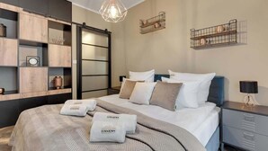 Un dormitorio moderno con cama, mesitas de noche, armario y estanterías empotradas.