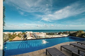 A swimming pool with a view of the ocean and cityscape. - Rooftop Pool Studio · Steps from 5th Ave & Beach (Playa del Carmen)