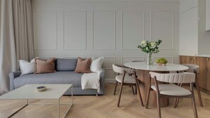 Een moderne woonkamer met een bank, salontafel en een eethoek.