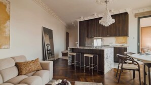 Ein modernes Wohnzimmer mit Sofa, Couchtisch und einer Deckenleuchte.
