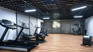 Ein Fitnessstudio mit Laufbändern, Crosstrainern und Gewichtsmaschinen.