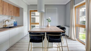 Una cucina moderna con schienale in marmo, mobili in legno e un'isola centrale con sgabelli da bar.