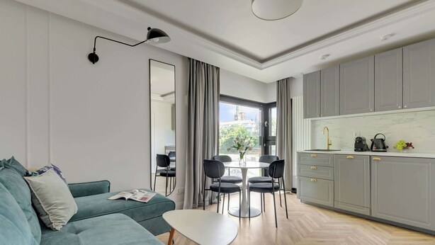 Una sala moderna con un sofá, una mesa de centro y un comedor con sillas y una mesa.