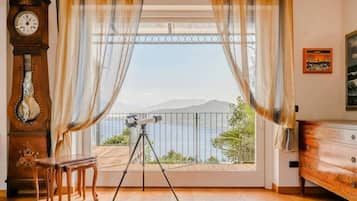 A room with a balcony, a telescope, a clock, and a dresser.