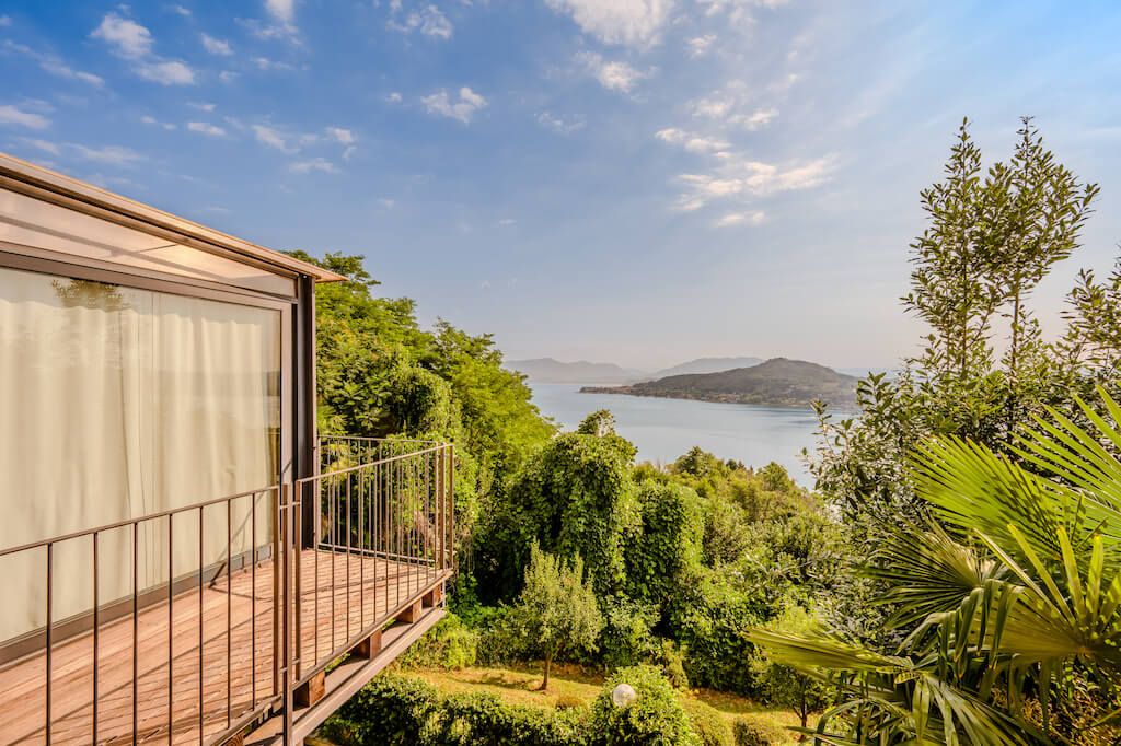 A balcony with a view of a lake and mountains.