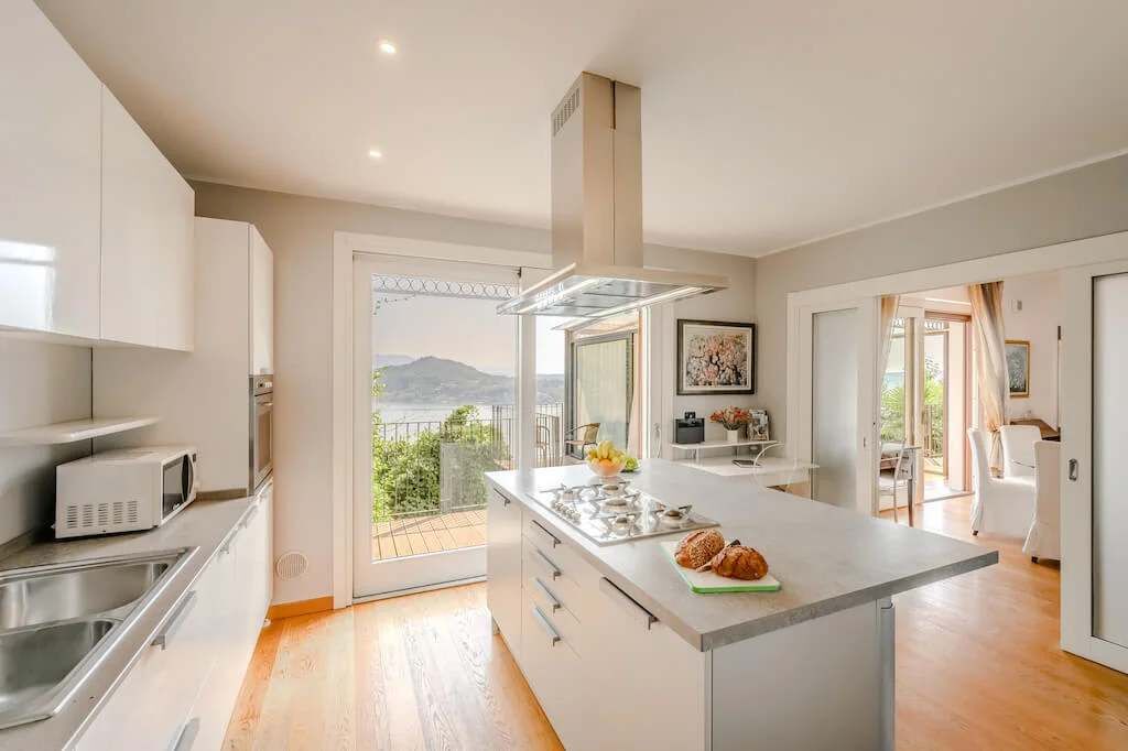 Una cocina moderna con una isla grande, electrodomésticos de acero inoxidable y vistas al exterior.