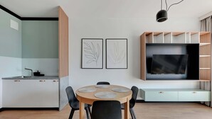 Una cucina moderna con angolo pranzo, televisore e opere d'arte alle pareti.