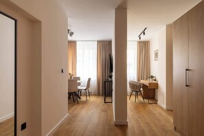 A modern interior with a dining area, a workspace, and a wardrobe. - Kraków Bohaterów Września 3 | AC | Parkside (Kraków)