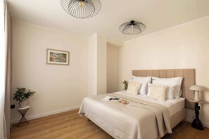 A bedroom with a bed, bedside table, lamp, and a picture on the wall. - Kraków Bohaterów Września 3 | AC | Parkside (Kraków)