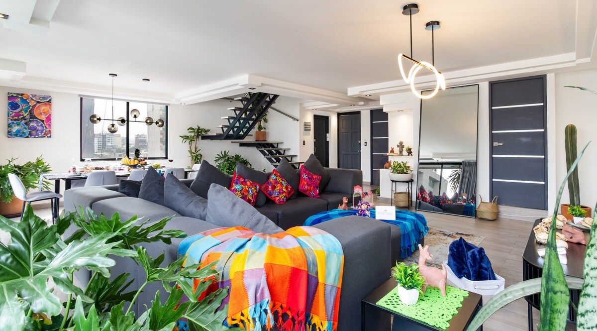 Colorful throws, plants and plenty of seats: the living room is made for movie nights with the whole group.
