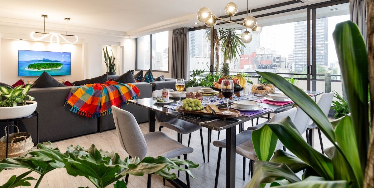 Ein modernes Wohnzimmer mit Essbereich, großen Fenstern und Blick auf die Stadt.