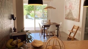 A dining area with a table, chairs, a hanging light, and a view of the outdoors. - Welcome to C'an Felip in Artà (Artà)