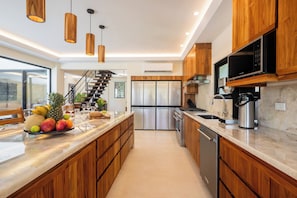 Eine moderne Küche mit Holzausstattung, Edelstahlgeräten und einer Marmorarbeitsplatte.