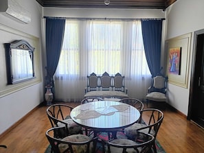 A dining area with a round table, chairs, and a window with curtains. - Karaagac Konagi Hotel (Bursa)