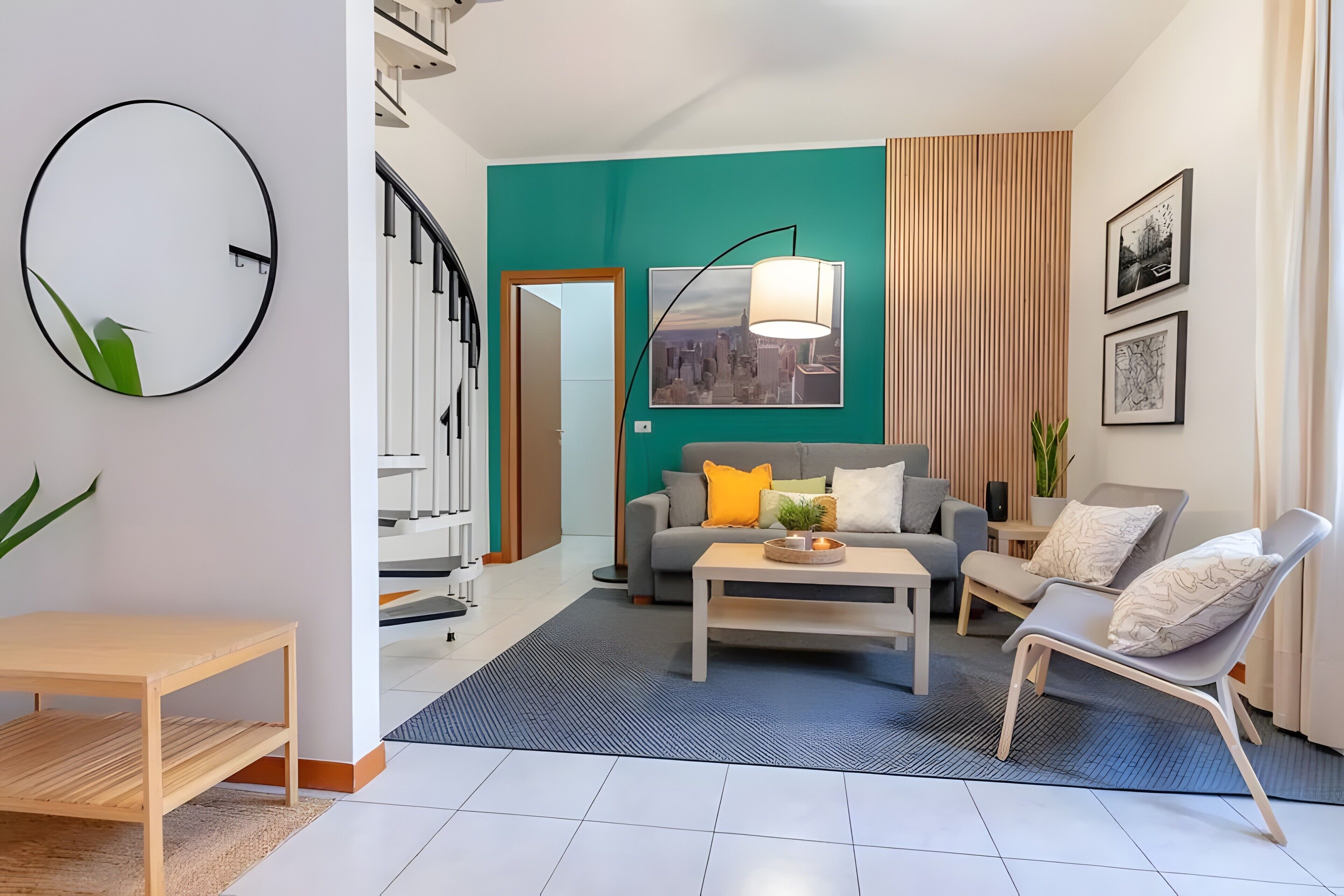 Ein modernes Wohnzimmer mit Sofa, Couchtisch und Sesseln, einer Treppe und einem Stadtbildgemälde.