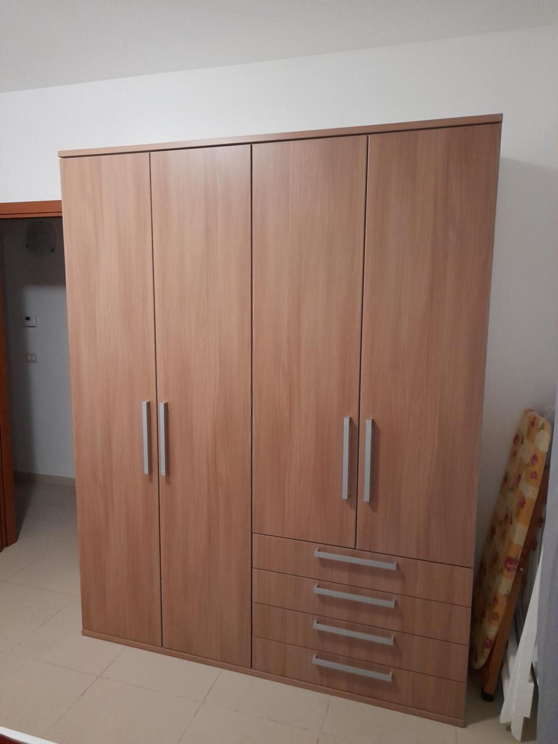 Une grande armoire à deux portes et dotée de nombreux tiroirs.