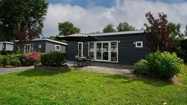 A modern single-story house with a patio, a small garden, and a clear sky. - Holiday Home in Dordrecht With Terrace (Dordrecht)