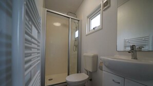 A bathroom with a toilet, a shower, a sink, and a mirror. - Holiday Home in Dordrecht With Terrace (Dordrecht)