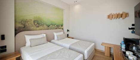 A hotel room with two beds, a painting on the wall, a wooden headboard, and a small table with a water bottle.