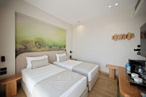 A hotel room with two beds, a painting on the wall, a wooden headboard, and a small table with a water bottle.