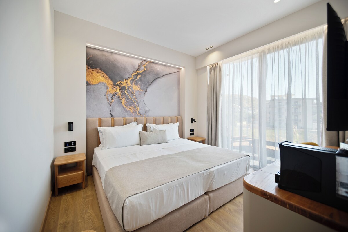 Una habitación de hotel moderna con una cama grande, un televisor de pantalla plana y vistas a la ciudad.
