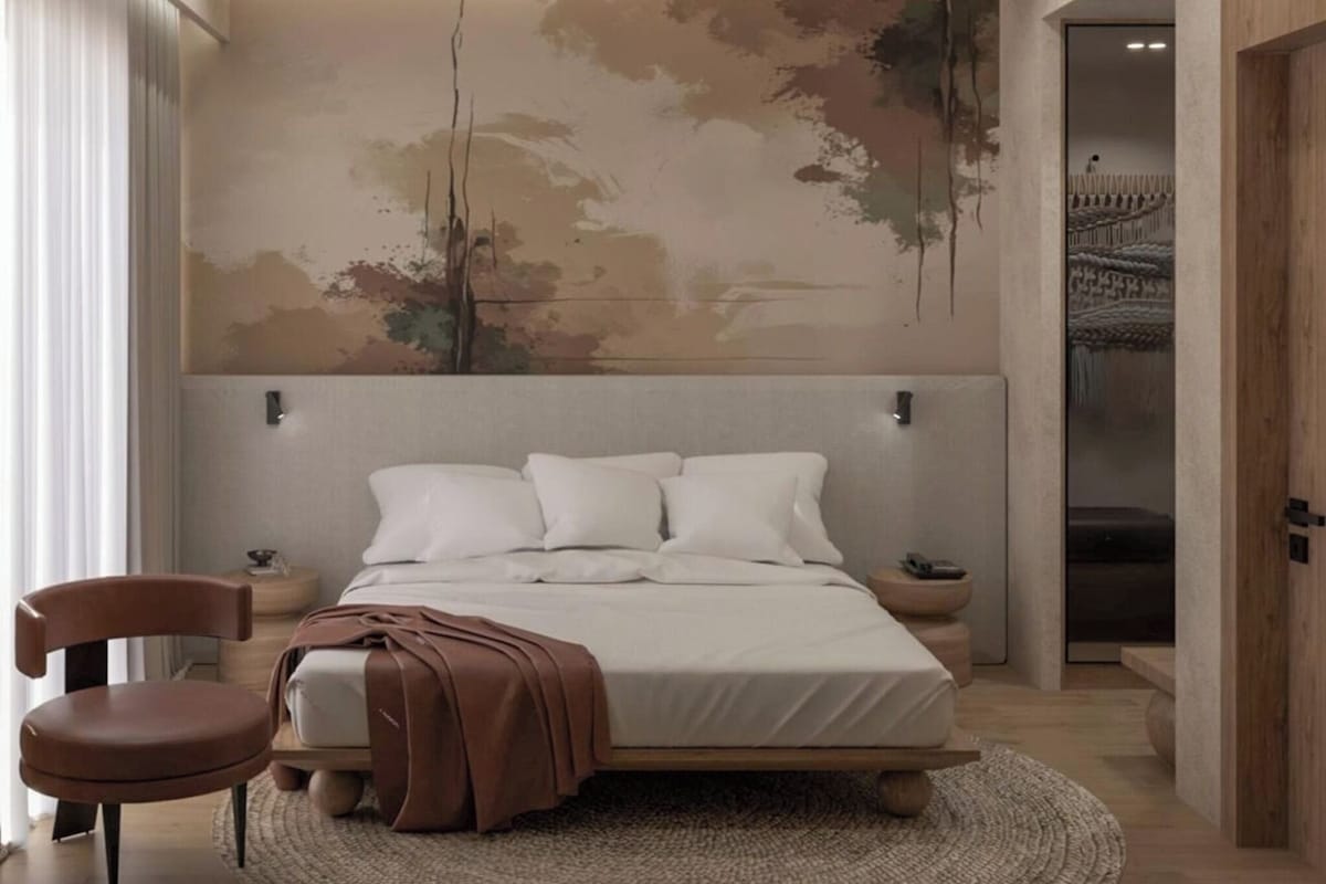 Un dormitorio moderno con una cama grande, cabecero, mesitas de noche, una silla y un mural abstracto de gran tamaño.
