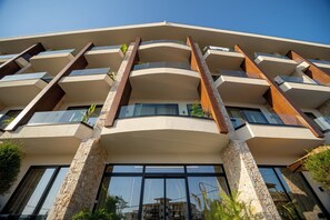 Un edificio de varios pisos con un diseño arquitectónico moderno, que presenta balcones y ventanas amplias.