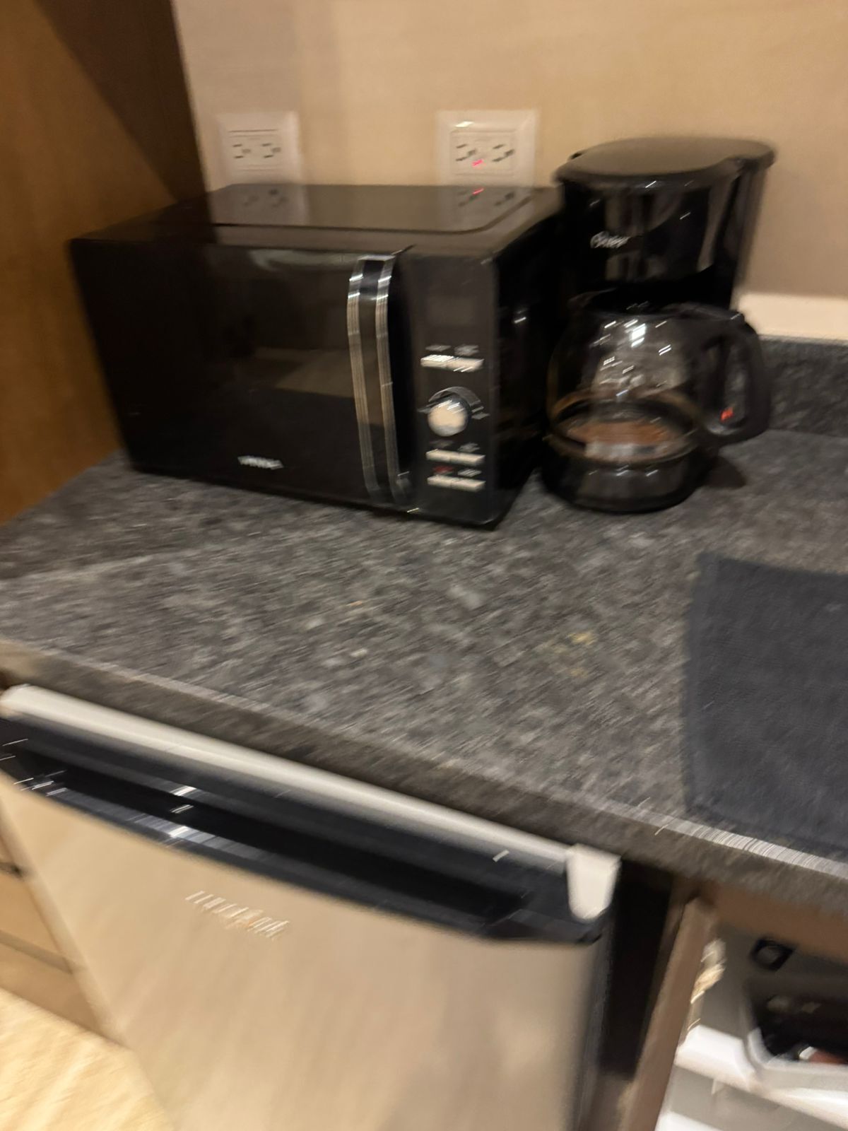 Une cuisine équipée d’un four à micro-ondes, d’une machine à café et d’un lave-vaisselle.
