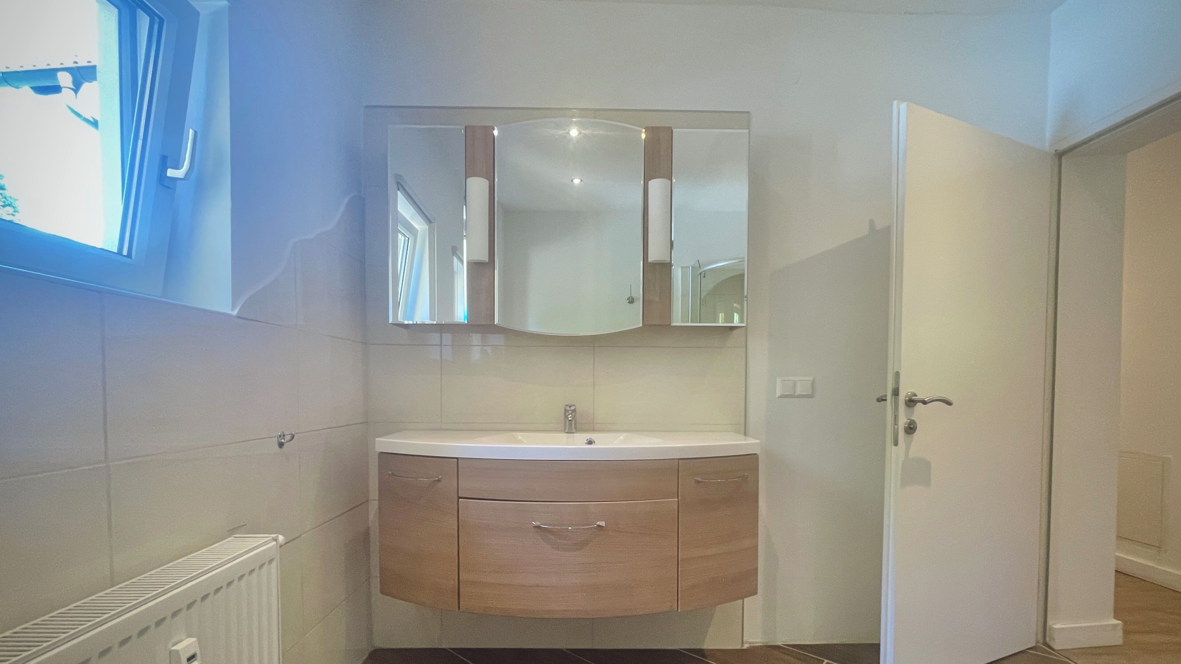 Une salle de bain avec un lavabo, un miroir et un meuble de rangement.