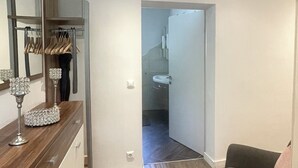 A modern interior with a wooden floor, a bench, a mirror, and a doorway leading to another room. - Velden Pool Apartment - Large apartment with a private pool (Velden am Wörthersee)