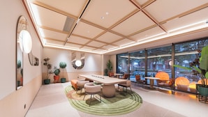 A modern interior with a central table, seating, and large windows.