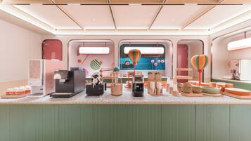 A modern interior with a counter displaying various items, a coffee station, and a view through a window.