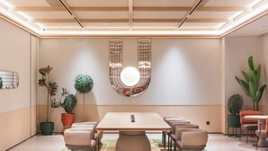 A modern conference room with a large table, chairs, and a unique wall decoration.