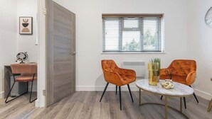 A modern room with a wooden floor, a dining table with two chairs, a window with blinds, and a door. - Beautiful-Cosy-King Bed-Studio perfect for couples (Greater London)