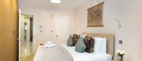 A hotel room with a bed, bedside table, and a map on the wall.